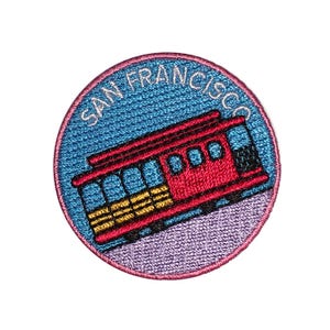 Op de afbeelding: Een geborduurde patch met een rode en witte kabelbaan met de tekst "SAN FRANCISCO".