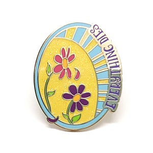 K&ouml;nnte beinhalten: Ein farbenfroher Emaille-Pin mit gelbem Hintergrund und zwei Blumen, eine rosa und eine lila. Der Pin hat einen blauen Rand und die Worte "EVERYTHING DIES" in Lila.