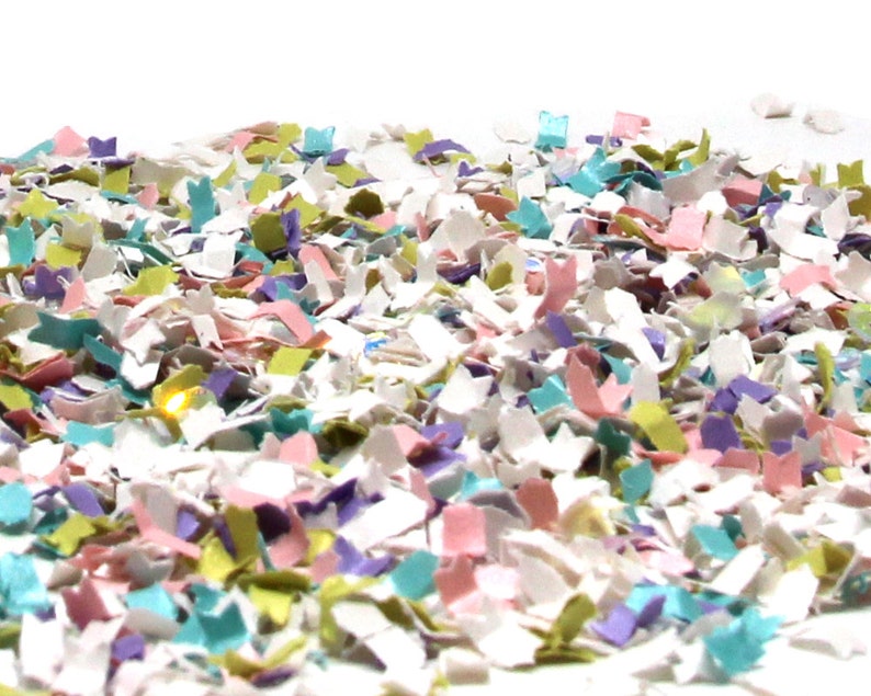 Puede incluir: Un mont&oacute;n de confeti colorido hecho de papel triturado en tonos de rosa, verde, azul y blanco.
