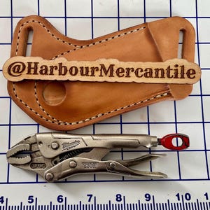 May include: A light brown leather tool holder with white stitching and a wooden tag that reads "@HarbourMercantile". Below is a silver and red locking pliers tool. The image is on a grid background.