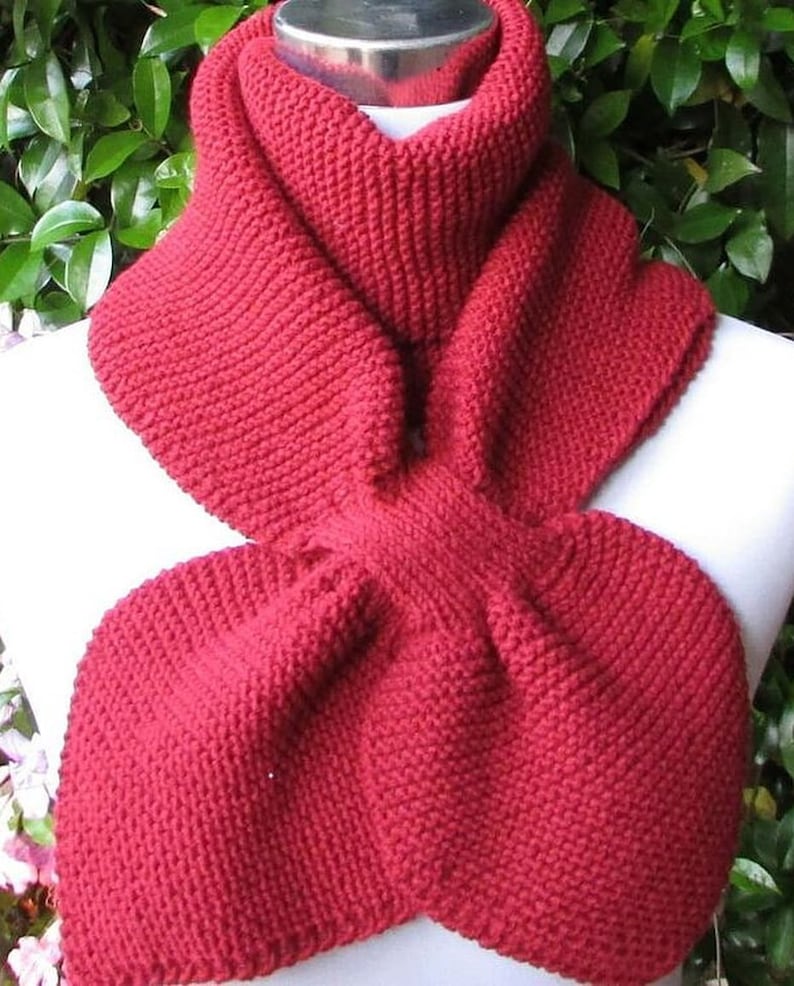 May include: A red knitted scarf with a unique looped design. The scarf is made of a soft, warm yarn and is perfect for keeping you cozy in the winter.