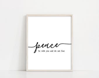 May include: A white framed print with black text that reads "peace be with you and do not fear."