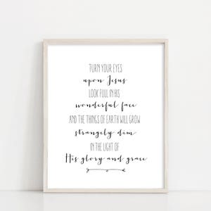 以下が含まれることがあります： 白い額縁に入ったプリントで、黒い文字で「TURN YOUR EYES upon Jesus LOOK FULL IN HIS wonderful face AND THE THINGS OF EARTH WILL GROW strangely dim IN THE LIGHT OF His glory and grace」と書かれています