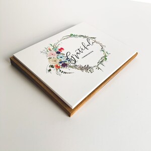 May include: A stack of white greeting cards with a floral wreath design and the word "grateful" in black script. The scripture "1 Chronicles 16:4" is printed below the word "grateful".