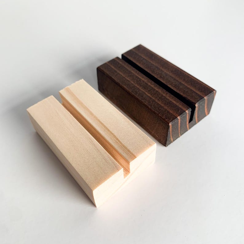 May include: Two wooden card holders, one is natural wood and the other is dark brown stained wood.