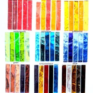 May include: A collection of rectangular glass strips arranged in rows and columns, categorized by color labels including red/burgundy, red/orange, gold/yellow, green, turquoise/aqua, blue, pink/purple, rainbow, and metallic, featuring varied textures.