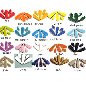 May include: A collection of twenty sets of teardrop-shaped ceramic mosaic tiles arranged in fan patterns. Each set features a distinct color including red, orange, yellow, green, blue, purple, pink, brown, black, gray, white, gold, and silver.
