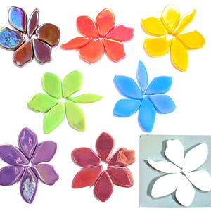 May include: A collection of eight flower-shaped arrangements made from individual glass petal pieces. The colors include iridescent brown, bright orange, yellow, lime green, sky blue, purple, reddish-pink, and solid white, each forming a six-petal blossom.