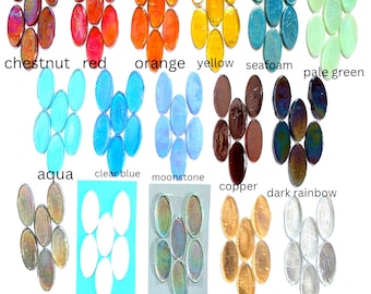 May include: A collection of oval-shaped glass cabochons arranged in groups by color, labeled as chestnut, red, orange, yellow, seafoam, pale green, aqua, clear blue, moonstone, copper, dark rainbow, gray, white, clear, gold foil, and silver foil.
