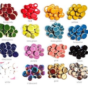 May include: A collection of sixteen groups of small, round, smooth ceramic tiles arranged in a grid. Each group features a distinct color including burgundy, red, orange, yellow, deep green, lime green, moss green, turquoise, deep blue, purple, pink, black, white, iridescent, gold, and silver.