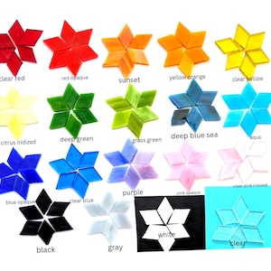 May include: A collection of diamond-shaped glass tiles arranged into star patterns, labeled with colors including clear red, red opaque, sunset, yellow orange, clear yellow, citrus iridized, deep green, grass green, deep blue sea, aqua, blue opaque, clear blue, purple, pink opaque, clear pink iridized, black, gray, white, and clear.