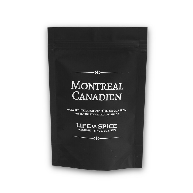 May include: A black pouch with white text that reads "Montreal Canadien" and "A classic steak rub with Gallic flair from the culinary capital of Canada." Below the text is the logo "Life of Spice Gourmet Spice Blends."