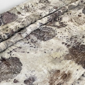 以下が含まれることがあります： 自然なリネン素材の生地で、茶色と白の葉の模様が特徴です。生地は、茶色、白、グレーの色合いで、微妙なまだら模様になっています。