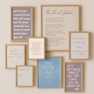 Può includere: Una collezione di stampe artistiche incorniciate con varie citazioni e frasi in diversi caratteri e colori. Le cornici sono in legno colorato chiaro e le stampe sono disposte su una parete di colore neutro. Le stampe includono frasi come "But I'm not a bad bitch" e "Stay strong".