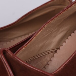 May include: Close-up of the inside of a brown leather shoe. The shoe has a brown leather lining and a brown leather sole.