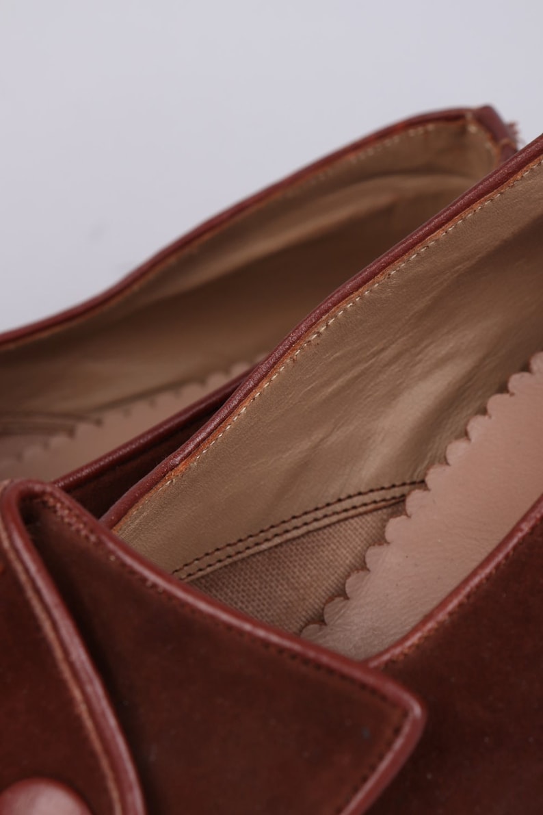 May include: Close-up of the inside of a brown leather shoe. The shoe has a brown leather lining and a brown leather sole.
