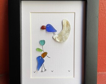 Sea glass art 33: two cobalt blue sea glass birds giving turquoise sea glass flower on shell crescent moon, black 2x3 frame, beach glass art