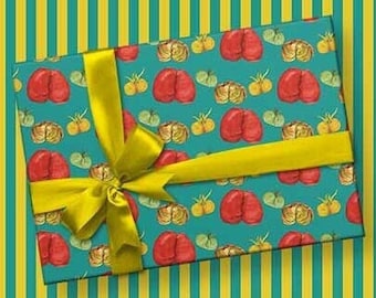 May include: A teal gift box with a yellow ribbon. The box is wrapped in paper with a repeating pattern of boxing gloves and tomatoes.