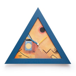 Könnte beinhalten: Eine dreieckige Wanduhr mit blauem Rahmen. Das Zifferblatt zeigt ein abstraktes Design mit orangefarbenen, gelben und schwarzen Formen. Die Zeiger sind blau und gelb. Die Uhr misst etwa 30 cm im Durchmesser.