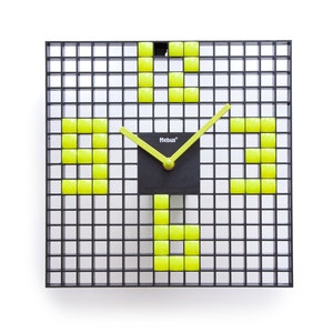 Puede incluir: Un reloj de cuadrícula negra con cuadrados amarillos que forman los números. La esfera del reloj es negra con la palabra "Mebus" impresa en ella.