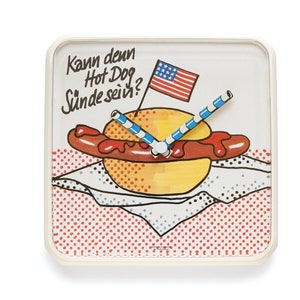Könnte beinhalten: Eine weiße quadratische Uhr mit einem Hotdog und einem Strohhalm als Zeigern. Das Zifferblatt der Uhr hat rote und weiße Punkte und den Text "Kann denn Hot Dog  Sünde sein?" Die Uhr hat auch eine kleine amerikanische Flagge.