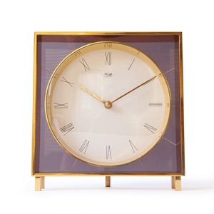 Könnte beinhalten: Eine weiße Keramik-Tasse mit schwarzem Henkel und dem Text "But First, Coffee" in schwarzer, handschriftlicher Schrift. Die Tasse steht auf einer weißen Oberfläche.