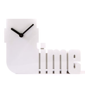 Puede incluir: Un reloj blanco moderno con manecillas negras, con la forma de la palabra « time ». La esfera del reloj tiene forma cuadrada, y la palabra « time » está en una fuente estilizada. Un objeto decorativo.