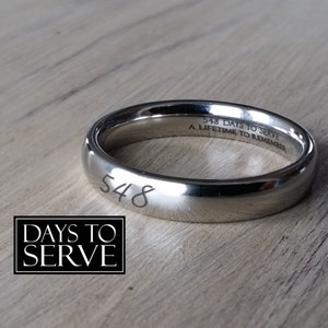 May include: A silver band with the number "548" engraved on the outside and the text "548 DAYS TO SERVE A LIFETIME TO REMEMBER" engraved on the inside.