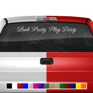 May include: White truck tailgate with a black rear window. The rear window has a white vinyl decal that reads "Look Pretty Play Dirty".