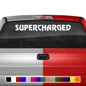 Può includere:  Adesivo in vinile bianco con il testo "SUPERCHARGED" sul portellone di un camion nero. L'adesivo è disponibile in una varietà di colori.