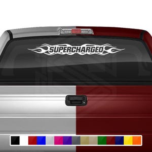 May include: White "SUPERCHARGED" decal with flame design on a vehicle's rear window. The text is flanked by flame graphics. The vehicle's bodywork is split between silver and maroon panels, with a selection of colour options below.