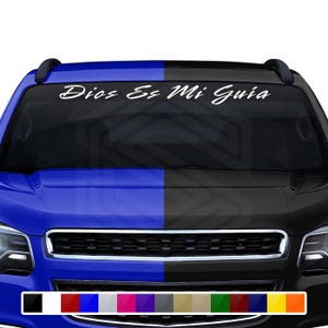 May include: A white decal with the text "Dios Es Mi Guia" is displayed across the top of a vehicle's windshield. The vehicle's hood is split, with the left side blue and the right side black. A color palette of options is shown at the bottom.