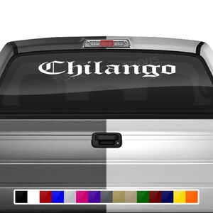 May include: White vinyl decal with the word "Chilango" in a gothic font style. The decal is applied to the rear window of a silver pickup truck.
