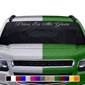May include: A white decal with the text "Dios Es Mi Guía" in a cursive font is displayed on the windshield of a vehicle. The vehicle's hood is split into white and green sections. A color palette of various hues is shown at the bottom.
