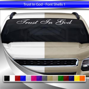Puede incluir: Calcomanía de vinilo blanco con la frase "Trust In God" en una fuente elegante, diseñada para aplicarse en el parabrisas de un vehículo. La calcomanía se muestra en un coche con una combinación de colores beige y blanco.