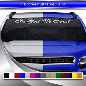 Puede incluir: Una calcomanía blanca con el texto "In God We Trust" en una fuente cursiva, que se muestra en el parabrisas de una camioneta azul y blanca.