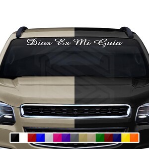 May include: A white vinyl decal with the text "Dios Es Mi Guía" is displayed on a car windshield. The vehicle's hood is split into two tones, beige and black. A color palette of various hues is shown at the bottom.