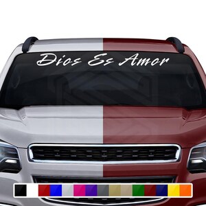 以下が含まれることがあります： 「Dios Es Amor」と書かれたフロントガラスのステッカーが付いた白いトラックです。