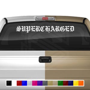 Puede incluir: Calcomanía blanca con la palabra "SUPERCHARGED" en fuente gótica en una ventana de camión negra.