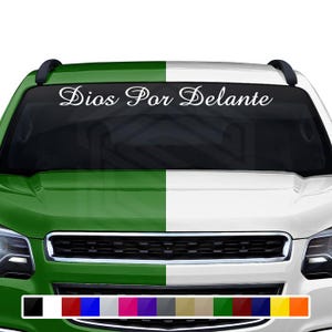 May include: A white decal with the text "Dios Por Delante" in a cursive font, applied to the windshield of a green and white vehicle. The vehicle has a black roof rack and a selection of color swatches at the bottom.