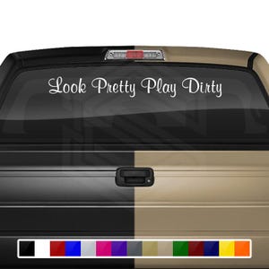 May include: White vinyl decal with the text "Look Pretty Play Dirty" on a black and tan truck tailgate.