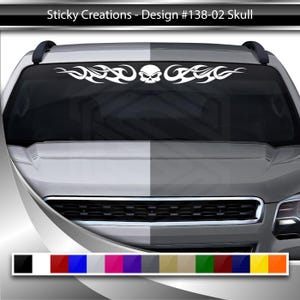 May include: A white skull with flames on either side, a car windshield decal. The decal is shown on a silver car. The decal is available in a variety of colours.