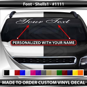 以下が含まれることがあります： 車のフロントガラス用の白いカスタムビニールステッカー。ステッカーには、筆記体で「Your Text」というテキストが書かれています。ステッカーはあなたの名前でパーソナライズされます。ステッカーは注文を受けてから作られます。