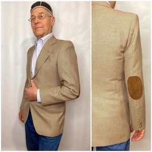 May include: A brown and tan plaid blazer with a suede elbow patch. The blazer has a single button closure and a notched lapel.