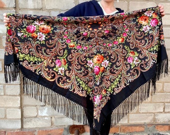 May include: A black shawl with a floral pattern and fringe. The shawl has a paisley design with red, pink, and yellow flowers.