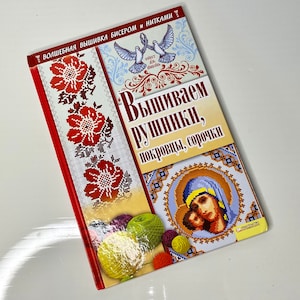 May include: A book titled "Вышиваем рушники, покрывцы, сорочки" with a red, white, and blue cover featuring cross-stitch embroidery designs. The book is about embroidery with beads and thread.