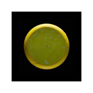 May include: A yellow disc with white marbling. The disc is smooth and round.