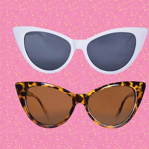 May include: Two pairs of cat-eye sunglasses. The top pair is white with gray lenses. The bottom pair is brown with brown lenses.