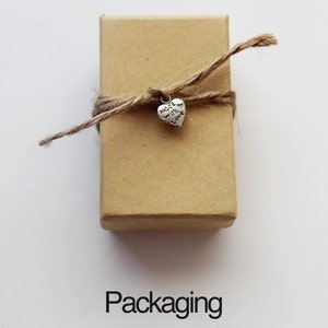 May include: A small brown box tied with twine and a silver heart charm that says "Made with Love".