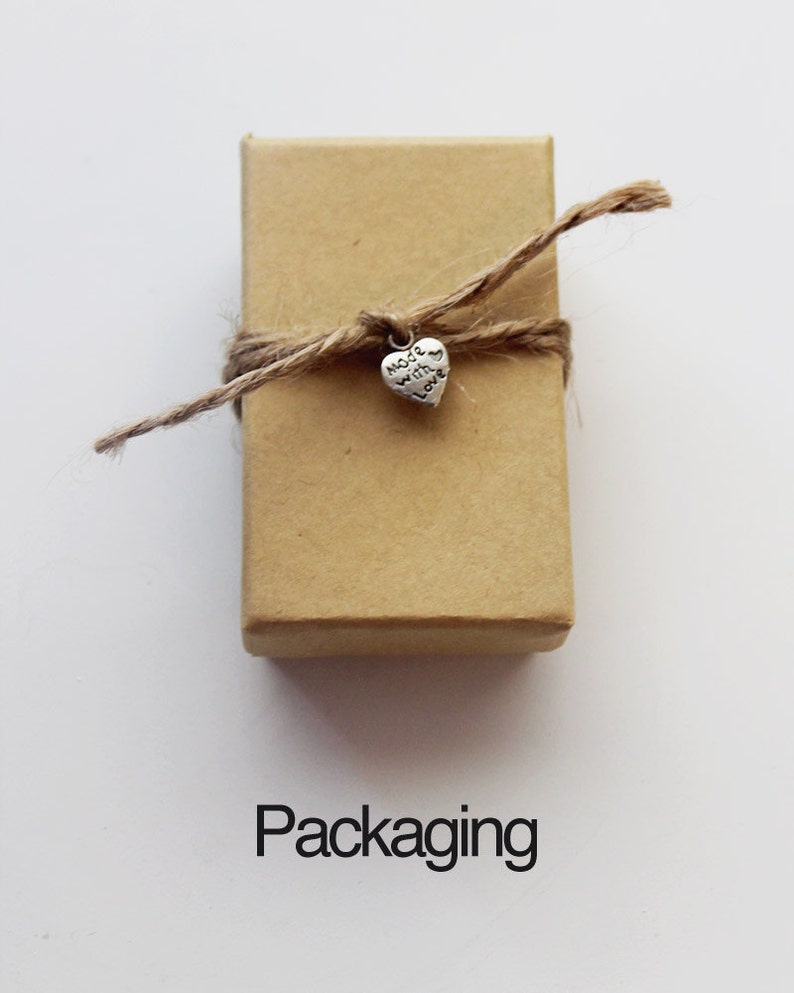May include: A small brown box tied with twine and a silver heart charm that says "Made with Love".